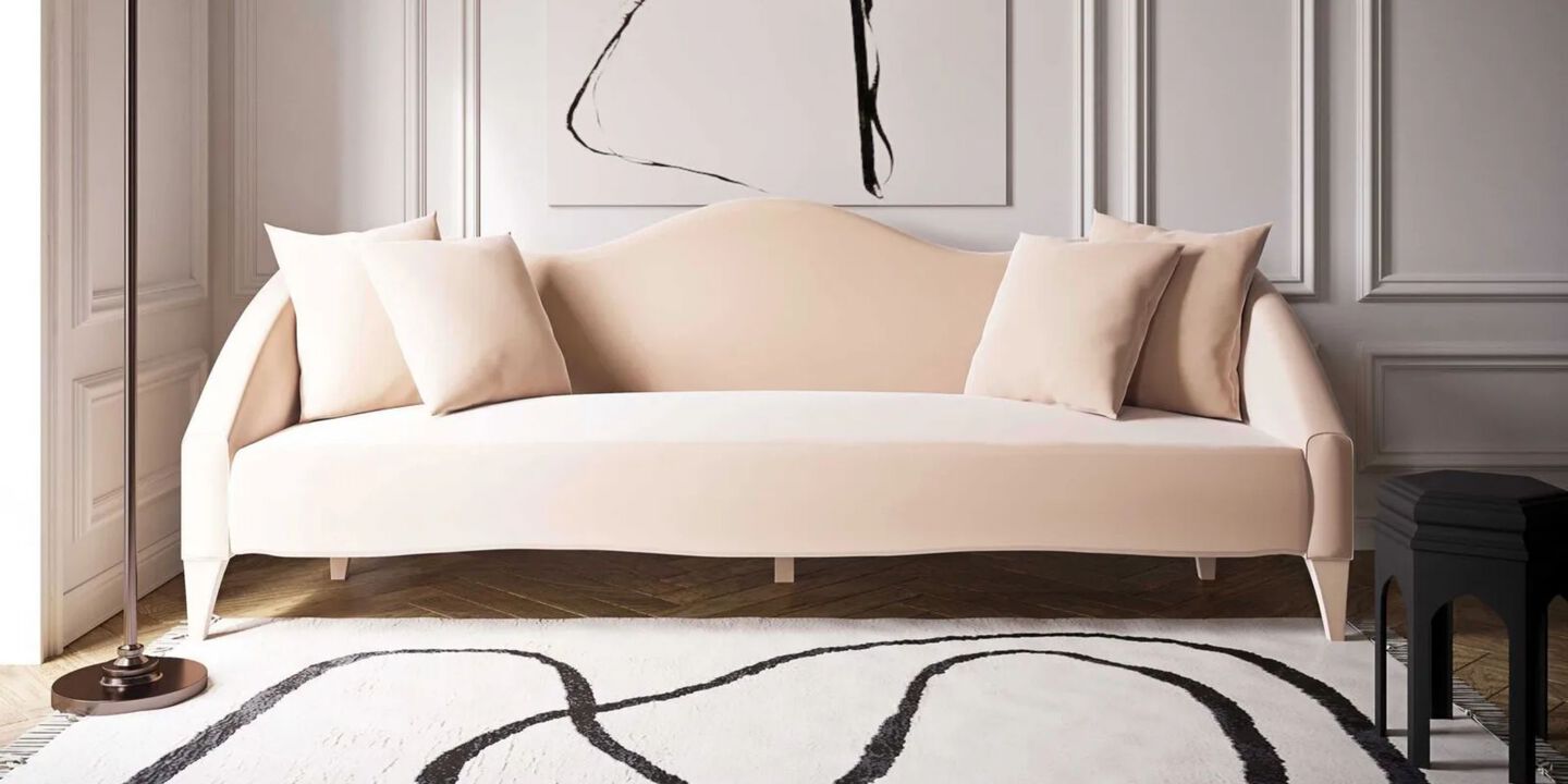 Light peach colored couch sitting on top of a black and white rug Light peach colored couch sitting on top of a black and white rug